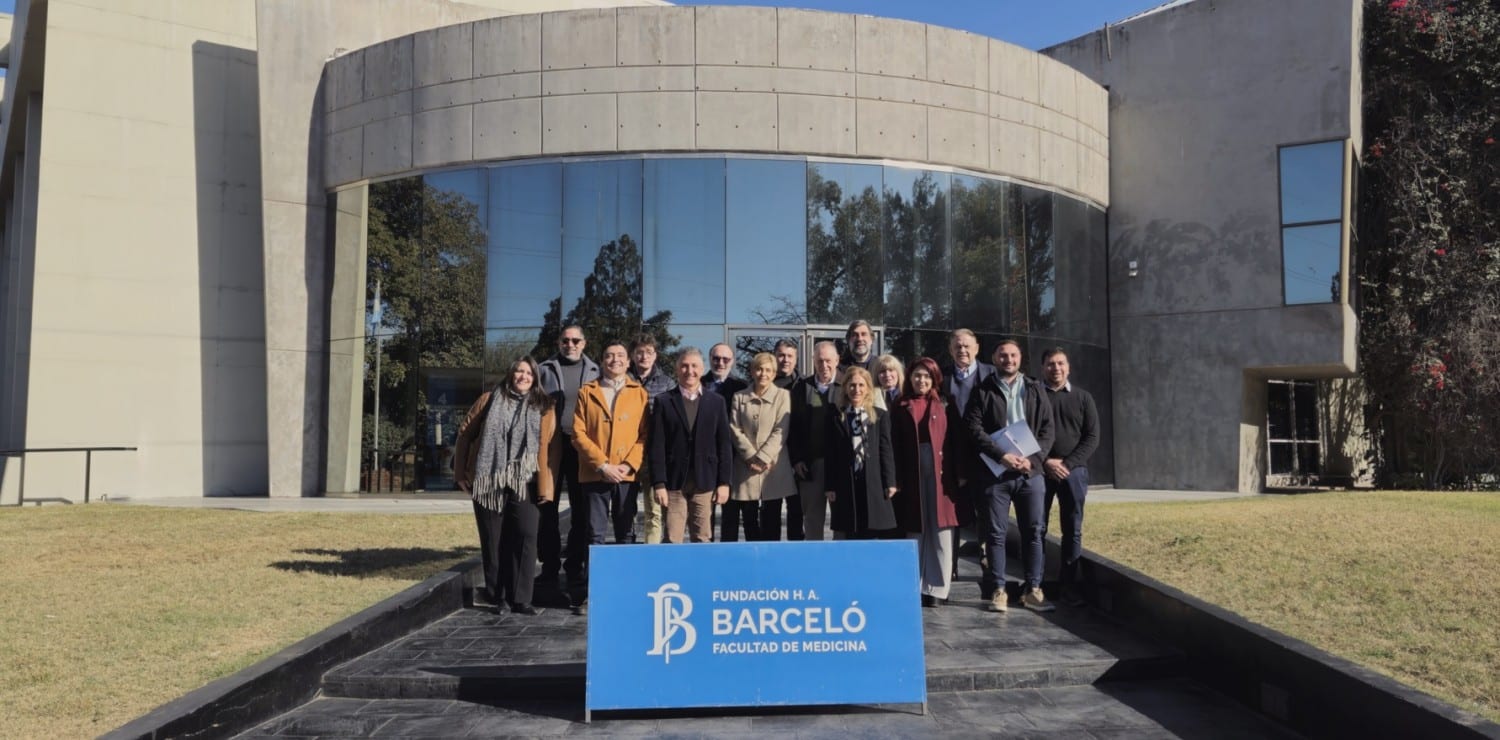 Grupo de asistentes frente a un edificio de la Fundación Barceló con fachada curva y ventanales
