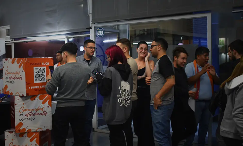 Grupo de estudiantes y asistentes conversando en una actividad de feria de empleo.