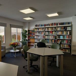 Sala de estudio con mesas, sillas y estanterías de libros
