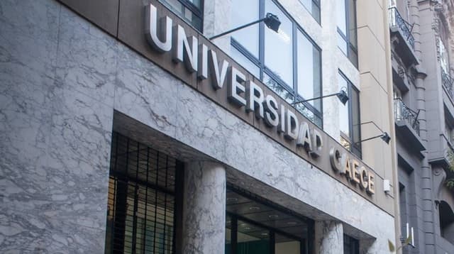 Fachada revestida en piedra con el nombre Universidad CAECE sobre el acceso.