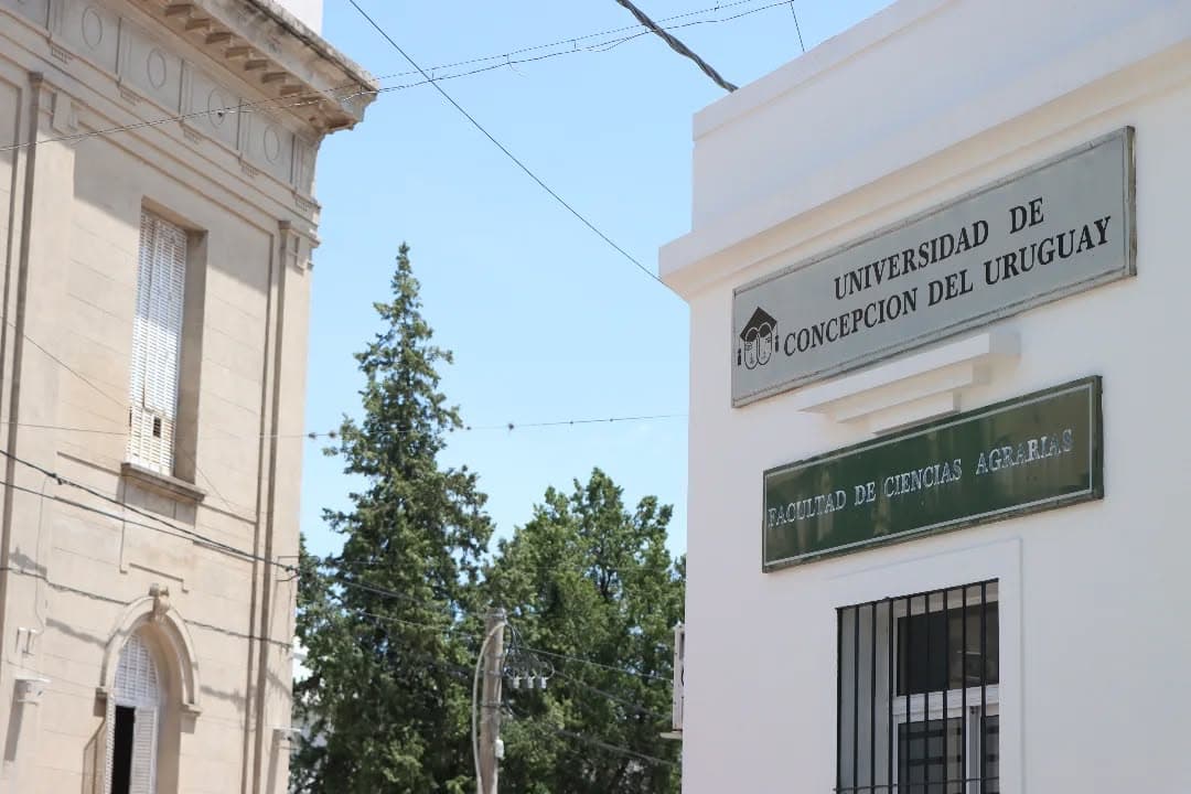 Acceso exterior con carteles de la Universidad de Concepción del Uruguay y de la Facultad de Ciencias Agrarias.