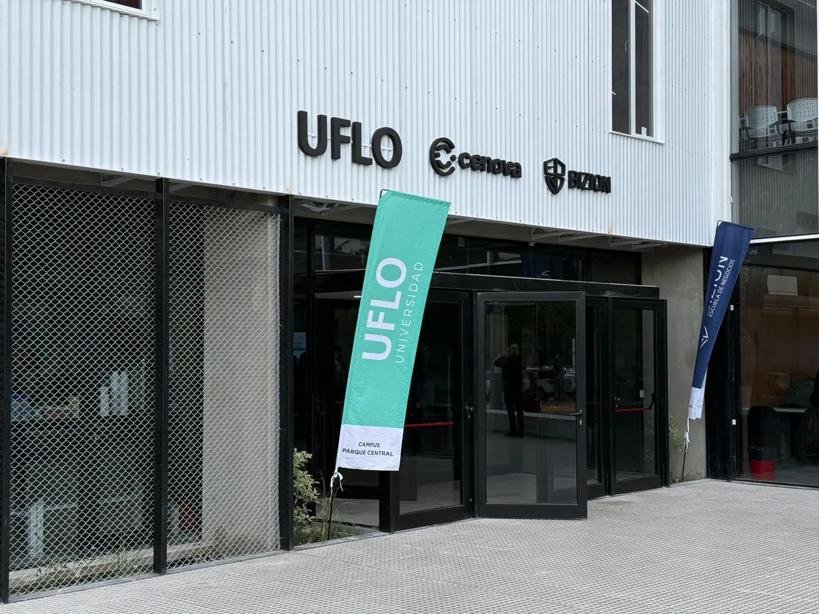 Acceso vidriado a un edificio con cartelería de UFLO.