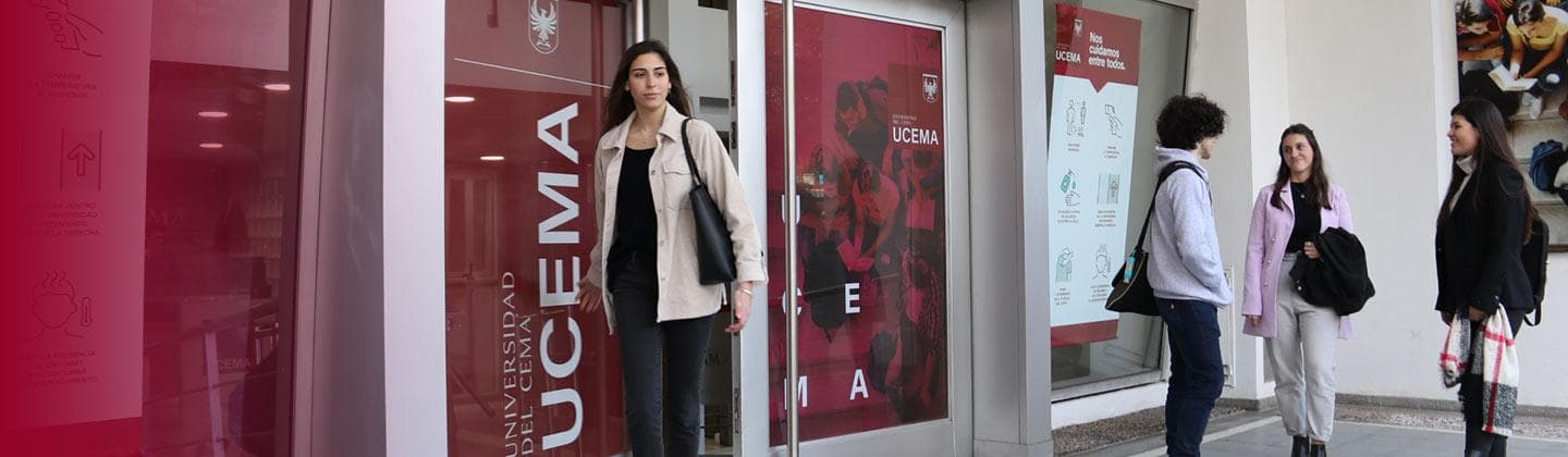 Estudiantes junto al acceso de una sede de UCEMA, identificado con carteles institucionales.