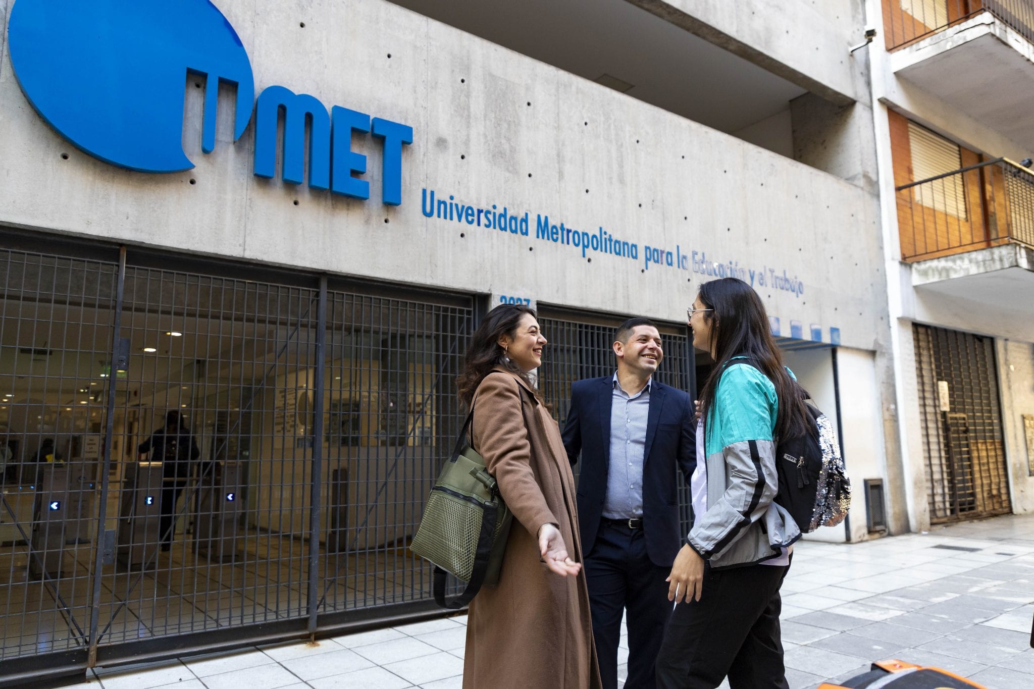 Fachada de la Universidad Metropolitana para la Educación y el Trabajo con estudiantes frente al acceso