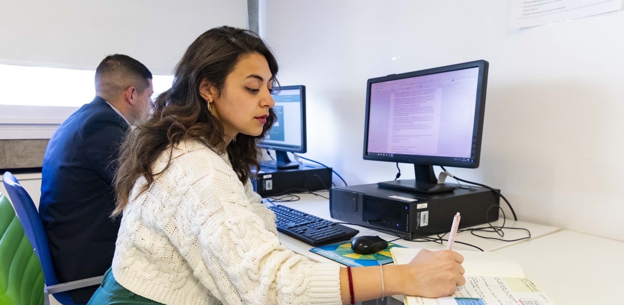 Estudiantes trabajando en computadoras en una sala de informática