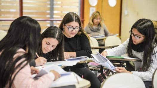 Estudiantes trabajando con apuntes en un aula