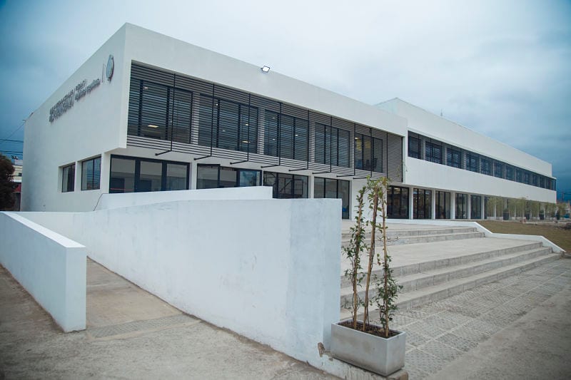 Fachada de un edificio de la Universidad Nacional de Hurlingham, con escalinata y ventanales.