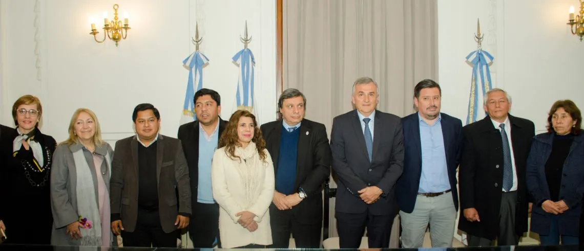 Grupo de representantes reunidos en un salón institucional.