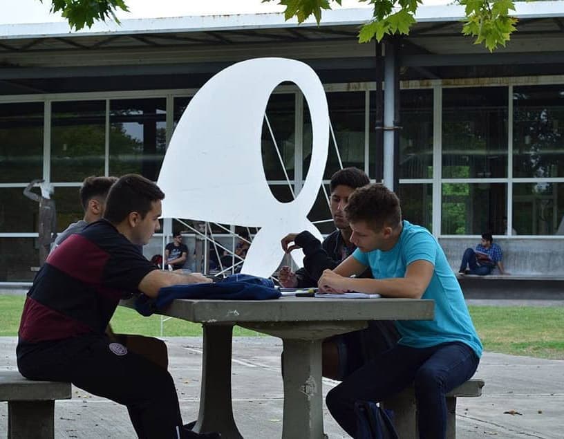 Estudiantes trabajando alrededor de una mesa al aire libre