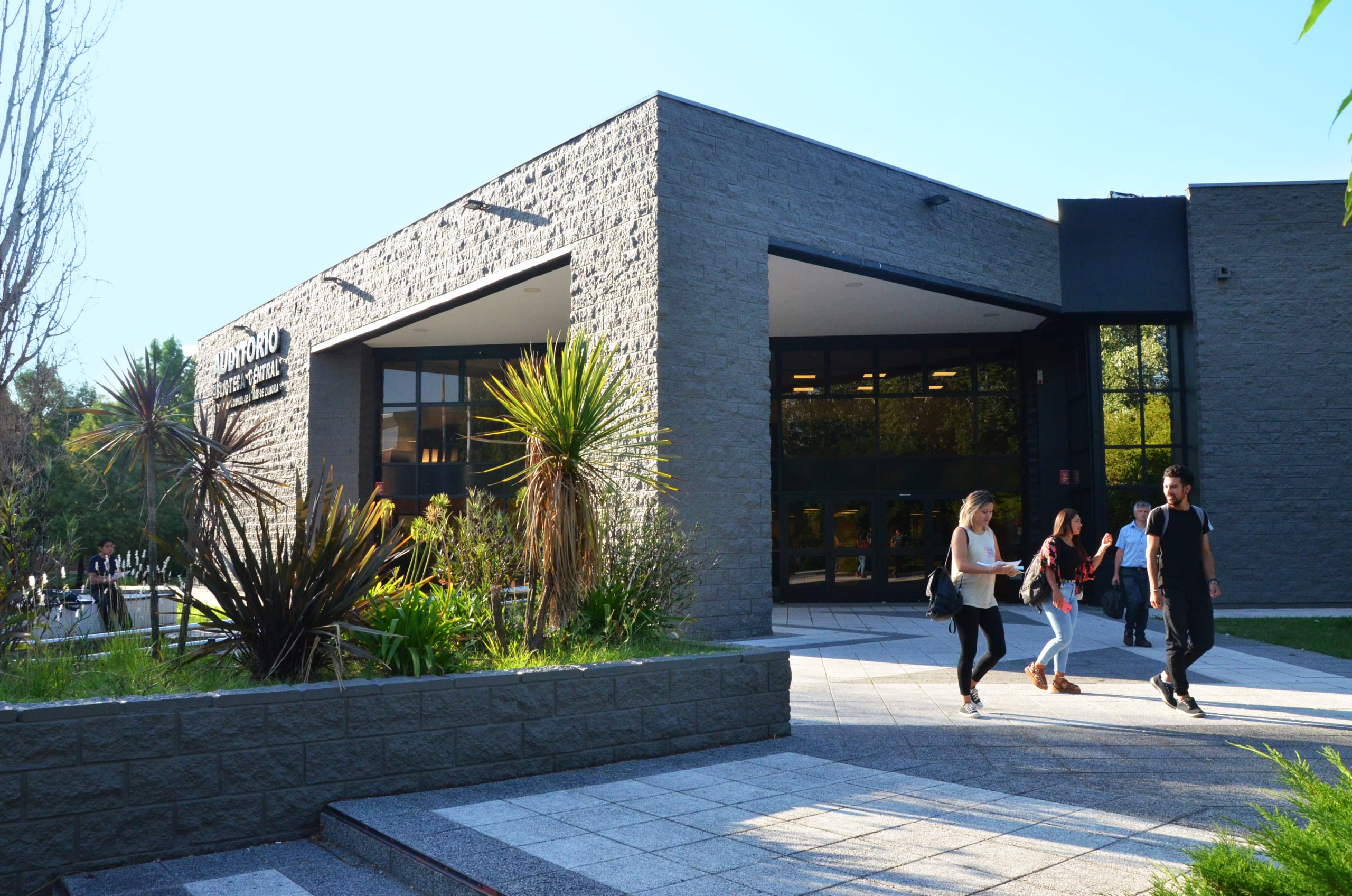 Exterior de la biblioteca de la Universidad Nacional de Lomas de Zamora, con estudiantes en el acceso.