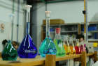 Mesada de laboratorio con matraces y recipientes de vidrio de colores