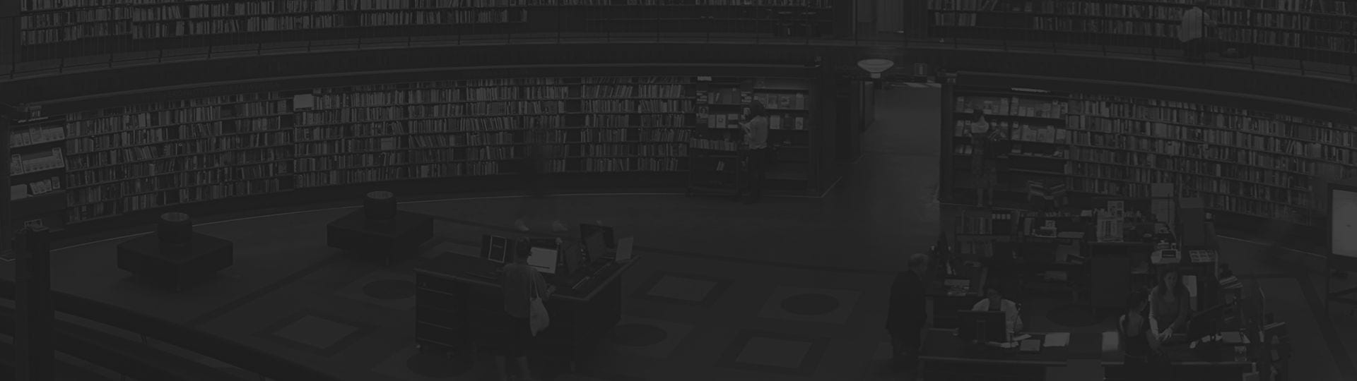 Vista panorámica del interior de una biblioteca, con estanterías y mesas de consulta.