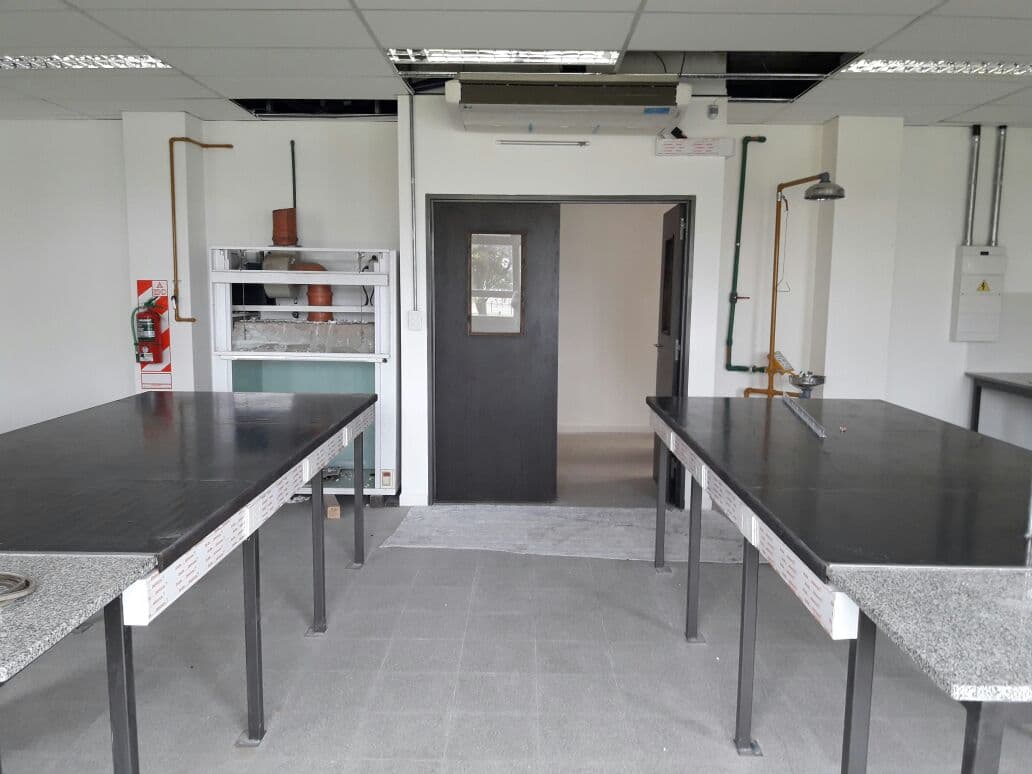 Laboratorio vacío con mesadas de trabajo, instalaciones y equipamiento fijo.