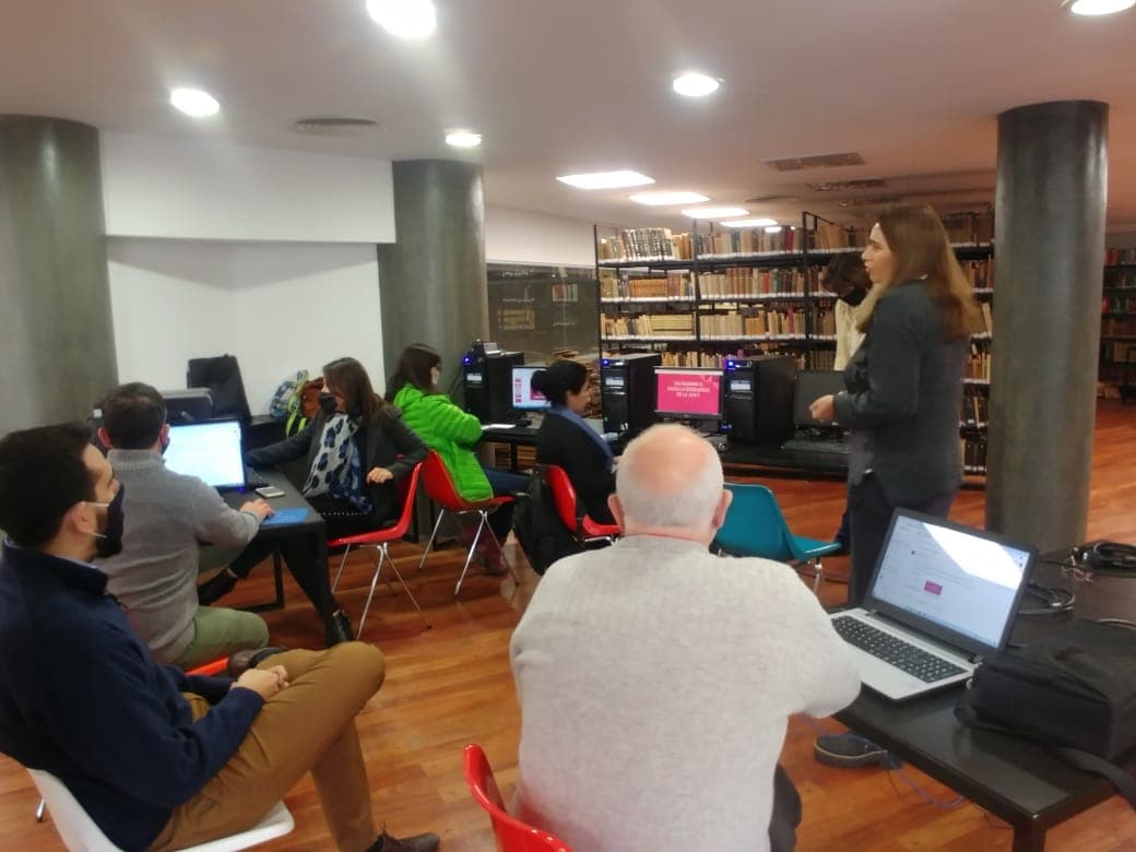 Personas participan de una capacitación con computadoras en una biblioteca