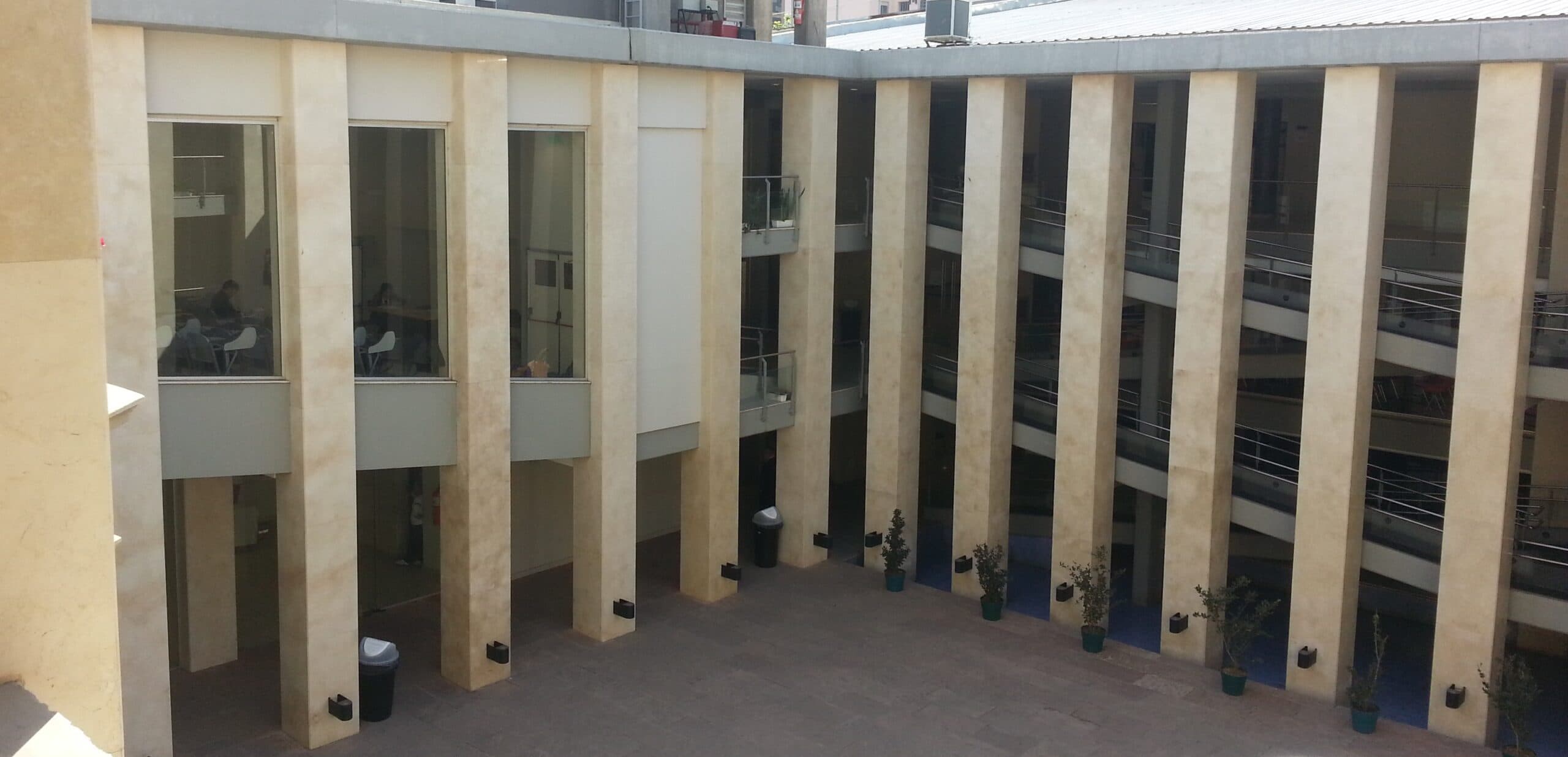 Patio interior rodeado por galerías y columnas en un edificio universitario