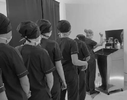 Grupo con indumentaria sanitaria durante una práctica en un espacio equipado.