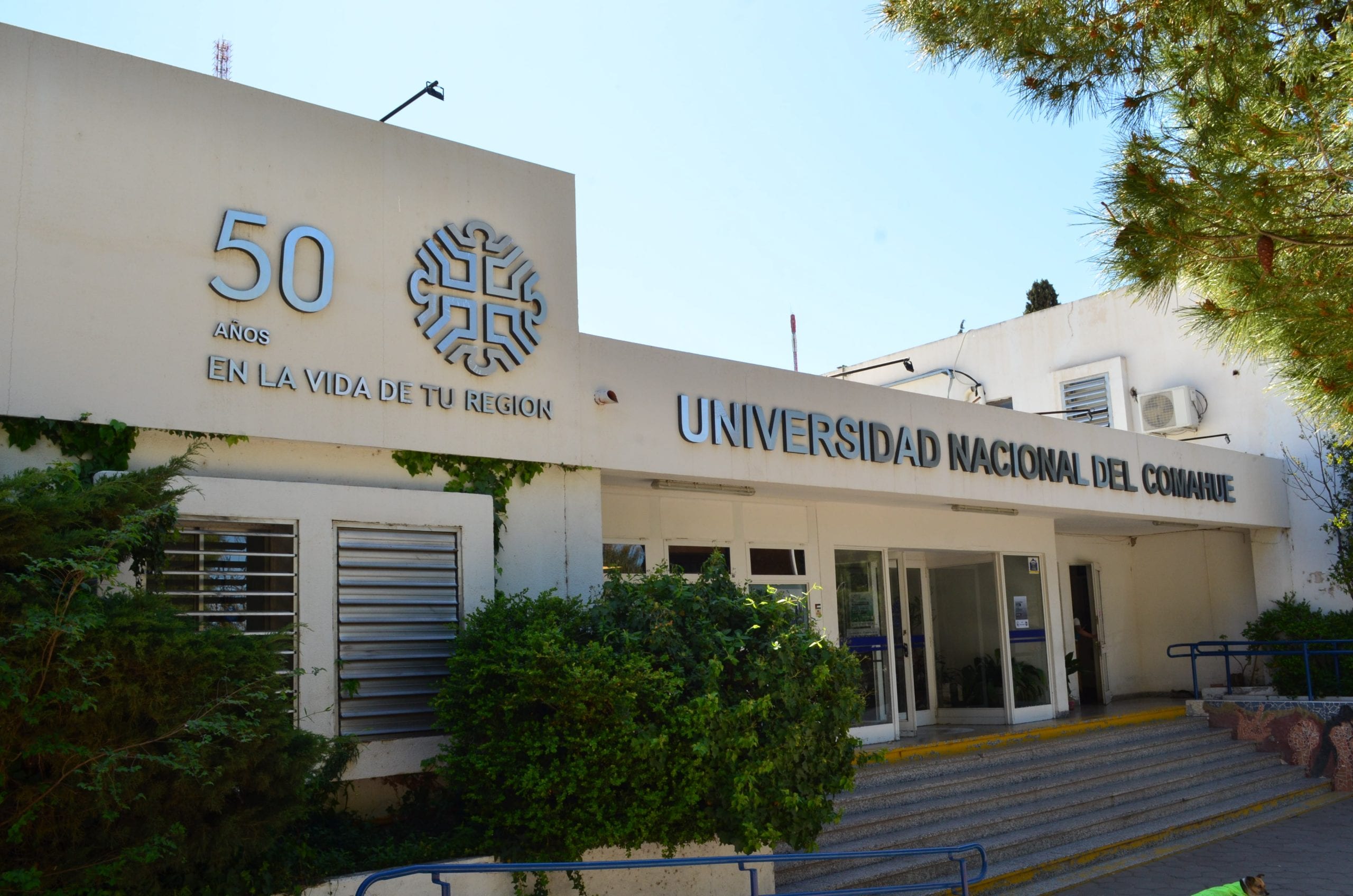 Fachada de la Universidad Nacional del Comahue con acceso principal y cartelería institucional