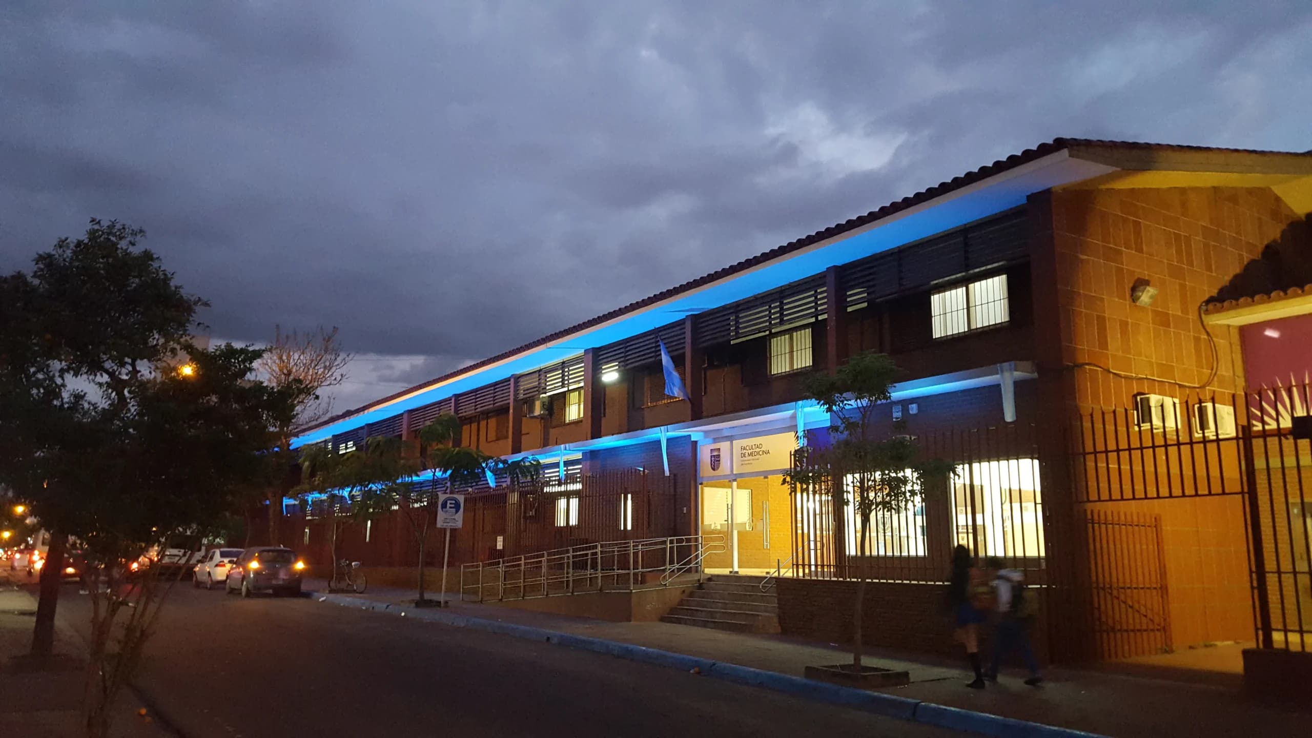 Edificio de la Facultad de Medicina iluminado al anochecer.