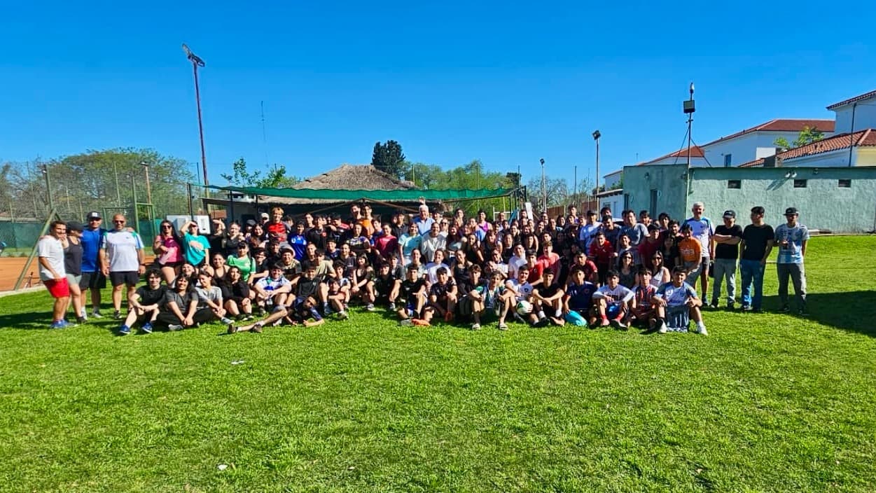 Grupo numeroso de estudiantes reunido en una cancha al aire libre